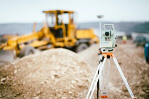 Surveyor equipment GPS system or theodolite outdoors at highway construction site.